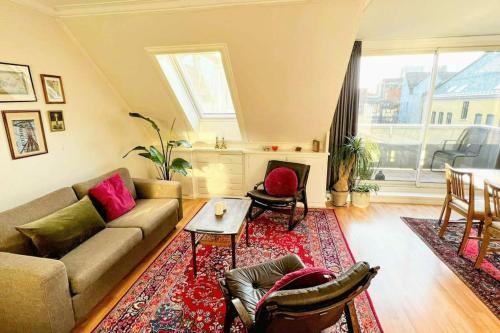 una sala de estar con un sofá y una mesa en Central 2BR with balconies and art in historical university area, en Bergen