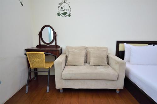 a bedroom with a bed and a chair and a mirror at Chin Shan B&B in Guanshan