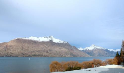 a view of a lake with snow covered mountains at Lakefront Apartments,18 LAKE ESPLANADE ROAD in Queenstown