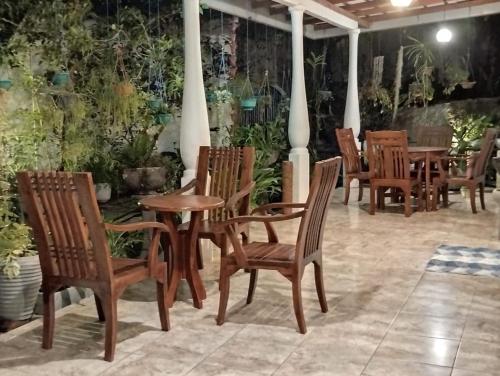 a group of wooden chairs and tables on a patio at Sinali Villa in Habaraduwa