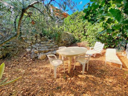 a table and two chairs and a table and chairs at Bas de villa au milieu des oliviers. in Chateauneuf Villevieille