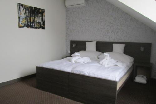 a bedroom with a bed with white towels on it at Wellness Hotel Vinnay in Vinné