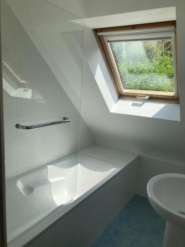 une salle de bain avec une baignoire et une fenêtre dans l'établissement Maison au dessus de la plage 6 personnes, à Saint-Michel-en-Grève
