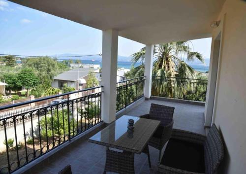 balcón con mesa, sillas y vistas al océano en Άνετο διαμέρισμα για 4 με θέα en Eretria