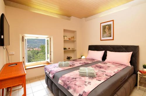 Un dormitorio con una cama grande y una ventana en Villa con giardino privato, tre camere, due bagni, en Manerba del Garda