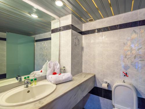 uma casa de banho com um lavatório e um espelho em Themis Beach Hotel em Kokkíni Khánion