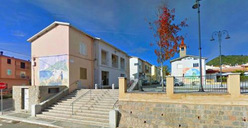un edificio con escaleras junto a un edificio con una señal de stop en Conchiglietta blu, en Cardedu