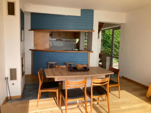 uma sala de jantar com uma mesa de madeira e cadeiras em Maison au dessus de la plage em Saint-Michel-en-Grève