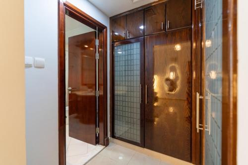 a bathroom with a glass door and a mirror at Marina Yacht Club Views - 3BR Modern Furnished in Dubai