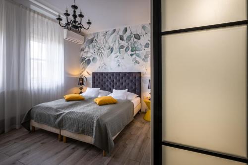 a bedroom with a bed with yellow pillows at Neptun Badacsony in Badacsonytomaj