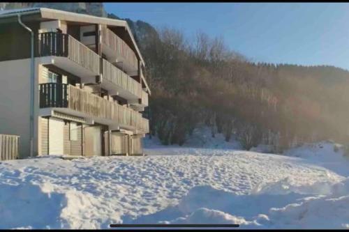 ein Gebäude mit Schnee auf dem Boden davor in der Unterkunft Studio Myrtilles du Léman vue sur lac et montagne in Thollon