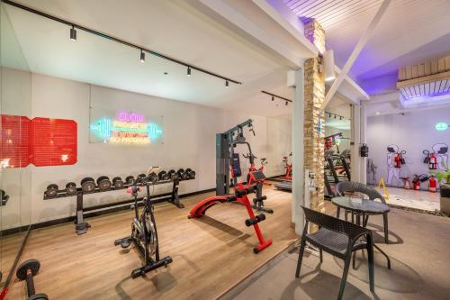 a gym with dumbbells and weights in a room at Qiu Hotel Sukhumvit SHA Plus in Bangkok