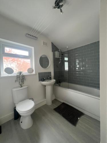 uma casa de banho branca com um WC e um lavatório em spacious 3 bed - EFC stays em Liverpool