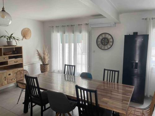 une salle à manger avec une grande table et des chaises en bois dans l'établissement Agréable maison de ville à 500 mètres de la cité, à Carcassonne