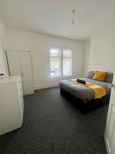 um quarto com uma cama e uma cómoda em spacious 3 bed - EFC stays em Liverpool