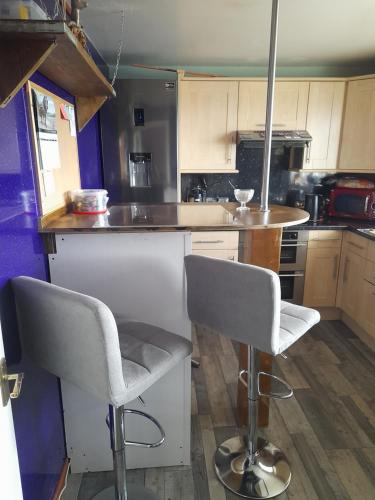 a kitchen with two chairs and a table in it at Cichy I uroczy pokój in Newtongrange