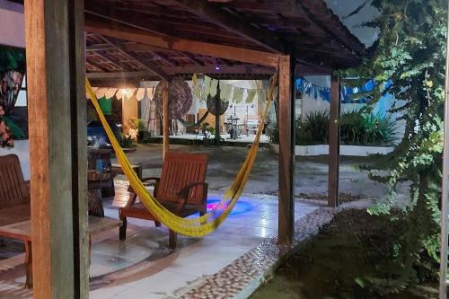 a porch with a hammock and a pergola at Residencial Maria de Lourdes in Ibicoara