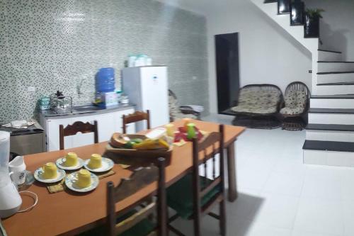 a kitchen with a wooden table and a table and chairs at Residencial Maria de Lourdes in Ibicoara