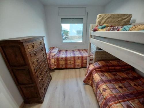 - une chambre avec 2 lits superposés, une commode et une fenêtre dans l'établissement Apartamento Roc Mar, à Llafranc