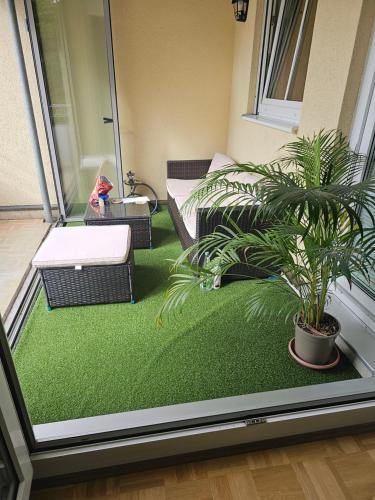 a balcony with a green floor with a plant at Privat Zimmer in 2 Zimmer Wohnung in Munich