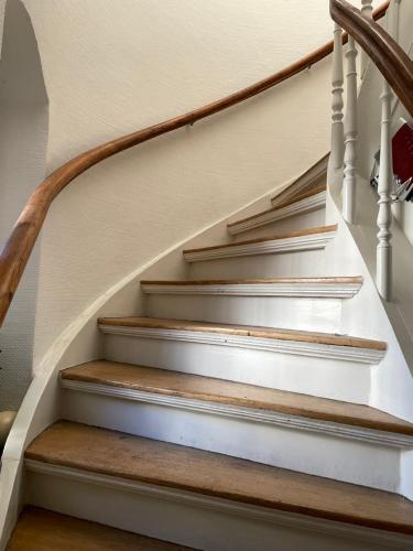 a staircase with white rails and wooden railings at Haus mit Türmchen in Solingen