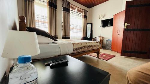 a bedroom with a bed and a bottle of water on a table at Thuring's Holiday Bungalow in Nuwara Eliya