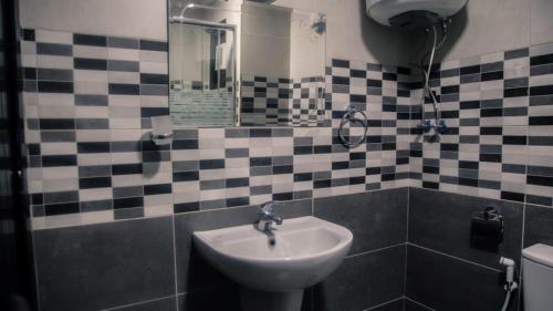 La salle de bains est pourvue d'un lavabo et d'un miroir. dans l'établissement Margarita Hotel, à Amman