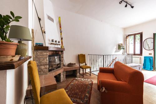 a living room with a fireplace and a couch at Casa Lola nel centro storico di Bolognola in Pintura di Bolognola