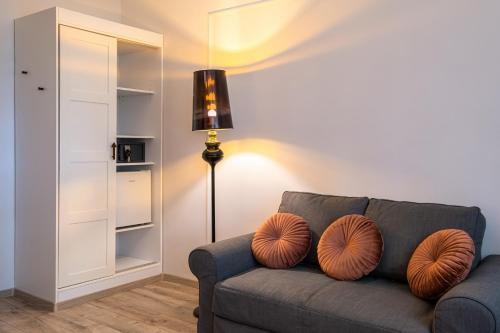 a living room with a gray couch with orange pillows at Neptun Badacsony in Badacsonytomaj
