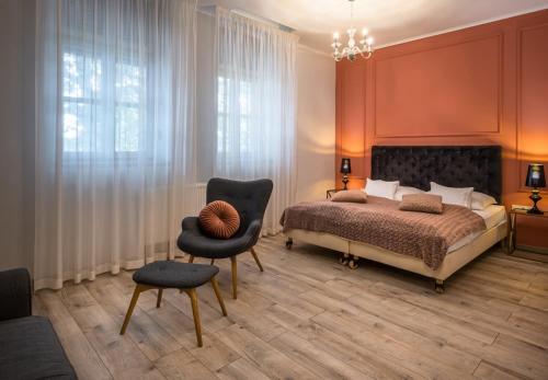 a bedroom with a bed and a chair at Neptun Badacsony in Badacsonytomaj