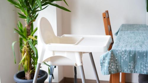 a white desk and chair next to a table and plants at TRIO apartment in Piešťany
