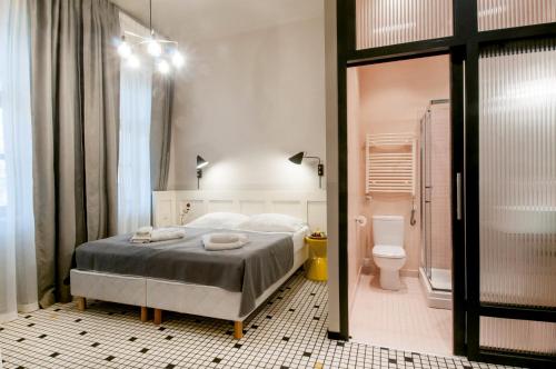 a bedroom with a bed and a bathroom with a toilet at Neptun Badacsony in Badacsonytomaj