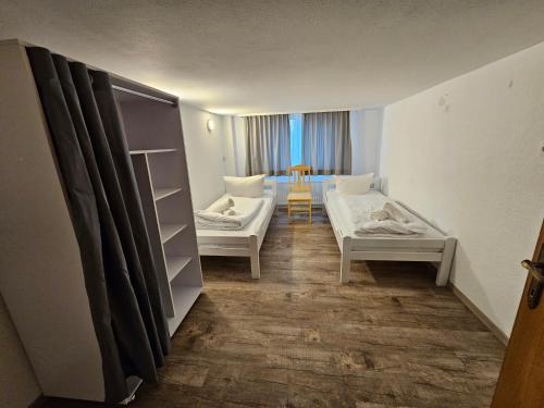a room with two beds and a room with a table at B76, Lauterach, Vorarlberg Apartments in Lauterach