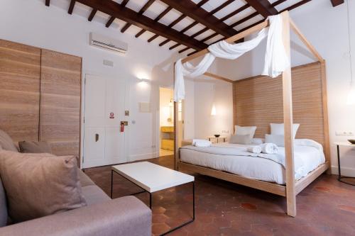 - une chambre avec un lit à baldaquin et un canapé dans l'établissement Can Roca Nou, à Port Mahon