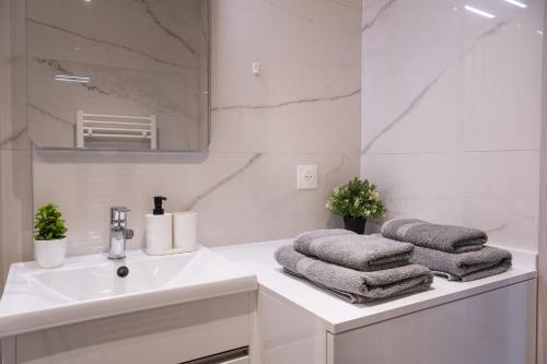 a white bathroom with a sink and a mirror at Studio calme et climatisé au cœur de Cannes in Cannes