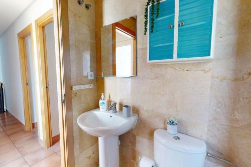 een badkamer met een wastafel, een toilet en een spiegel bij Beautiful 3 bed villa on Mar Menor golf resort in Torre-Pacheco