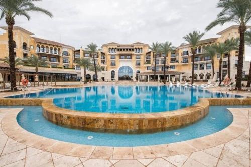 een groot zwembad voor een gebouw met palmbomen bij Beautiful 3 bed villa on Mar Menor golf resort in Torre-Pacheco