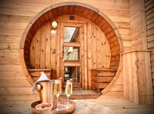 a wooden cabin with a window and two wine glasses at Le Sanglier Amoureux in Érezée