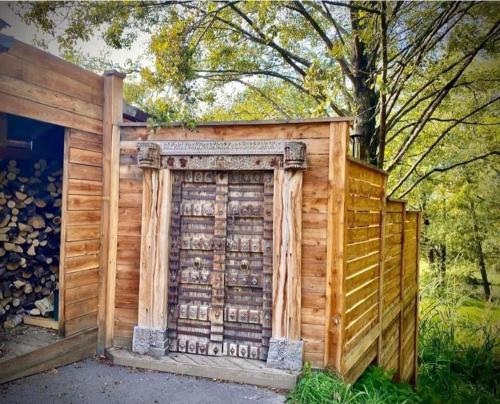 a wooden building with a gate and a fence at Le Sanglier Amoureux in Érezée