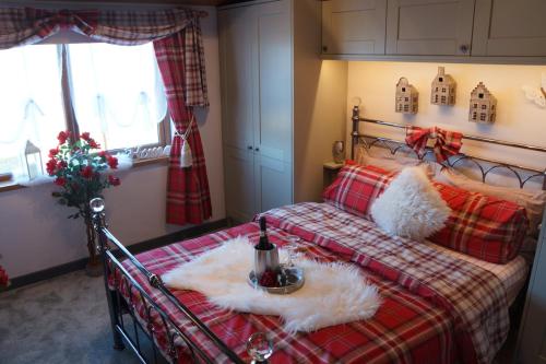 a bedroom with a bed with a red plaid blanket at West Horizon holiday cottage in Lochinver