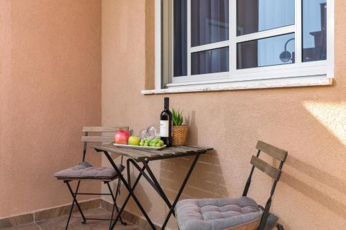 una mesa con una botella de vino y dos sillas en La suite Eilat, en Eilat