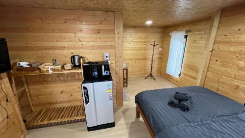 Habitación con cama en una cabaña de madera en BaanSuan Marigold บ้านสวนมาลีโกลด์, en Ban Madua Chumphon