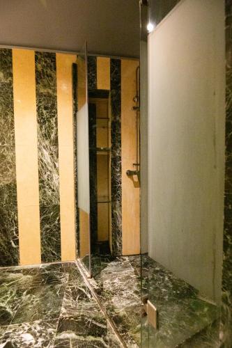 a bathroom with a glass shower and a glass door at Civitas Suites Hotel in Rethymno Town