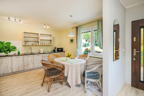 a kitchen and dining room with a table and chairs at Bednarzówka in Nowy Tomyśl