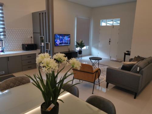 a living room with a couch and a table with flowers at Anjung Barakah Chalet in Kuala Terengganu