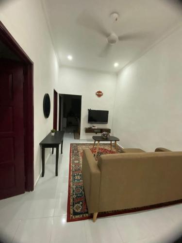 大山腳的住宿－Tok Abah Homestay Bukit Mertajam，客厅配有沙发和桌子