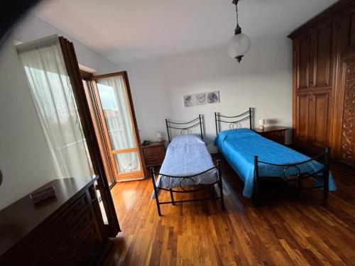 um quarto com uma cama azul e piso em madeira em A casa di Antonella em Biella