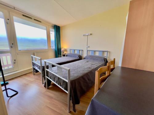 1 Schlafzimmer mit 2 Betten und einem großen Fenster in der Unterkunft La Mongie - Apt 2 ch - 8 pers - Place parking couvert in La Mongie