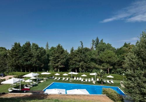 a resort with a pool and lounge chairs and umbrellas at Il Castagneto Hotel in Melfi