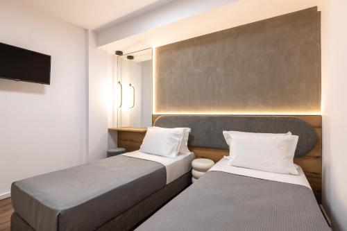2 Betten in einem kleinen Zimmer mit einem TV in der Unterkunft The five star apartment in Thessaloniki